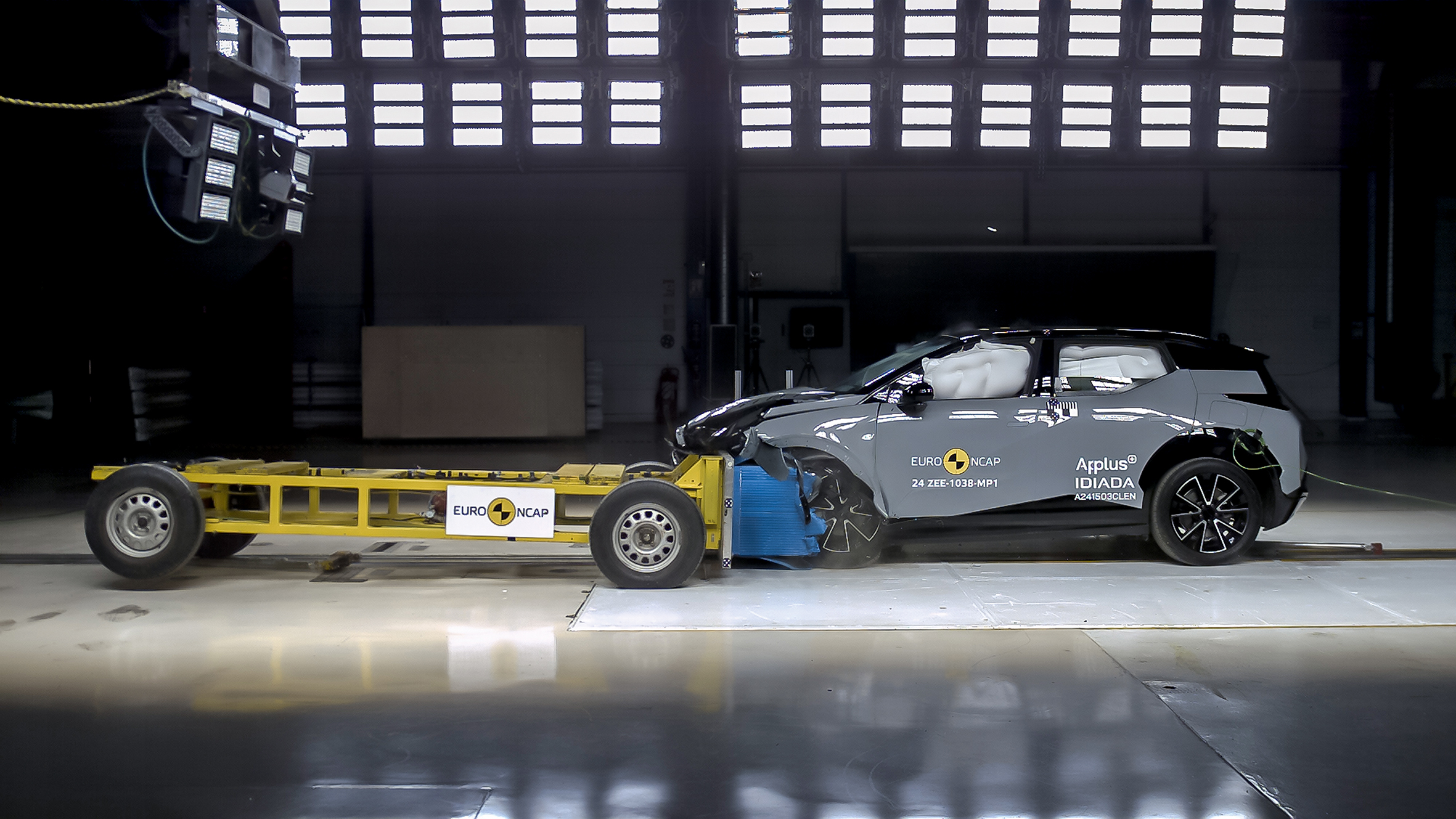 Zeekr X undergoing a frontal collision test at Euro NCAP, with airbags deployed and impact damage to the front of the vehicle.